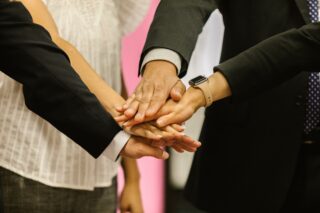 Hands of professionals stacked together.